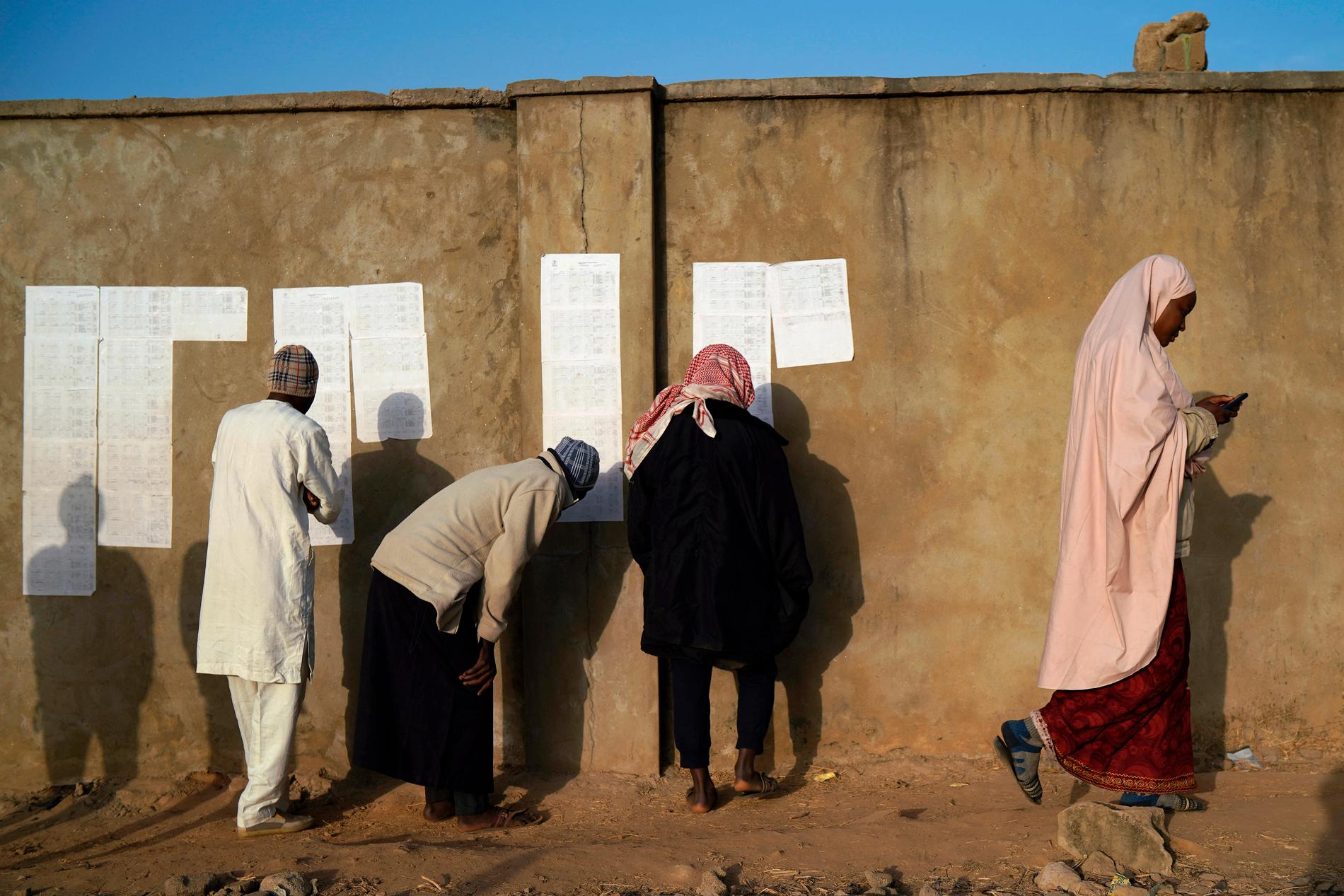 Väljarlistor kontrolleras vid en vallokal i Kaduna i Nigeria – vars planerade val i lördags dock sköts upp.