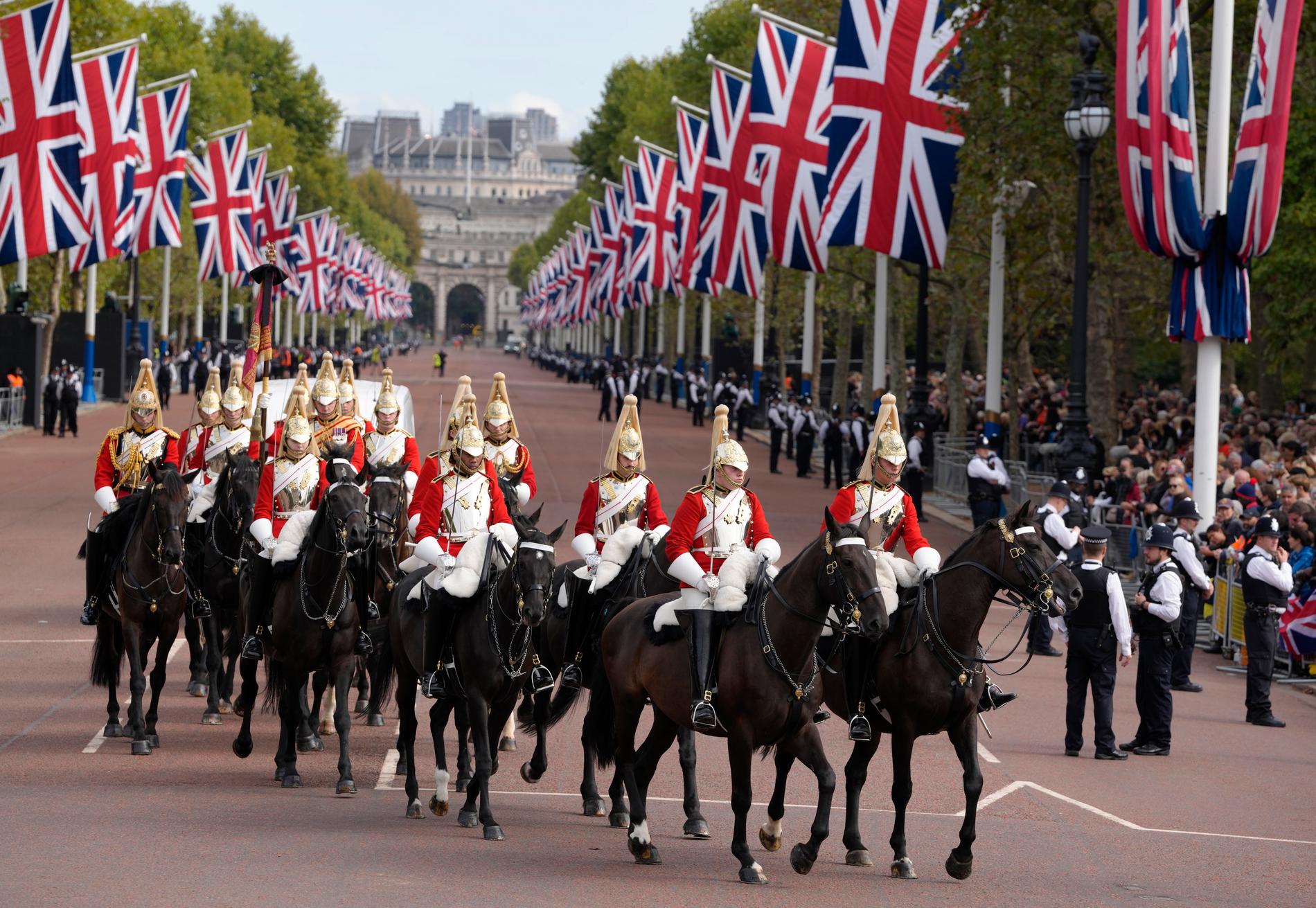 Det beridna hushållskavalleri, först i processionen från Buckingham Palace till Westminster Hall i London.  Tusentals människor kantade gatorna.