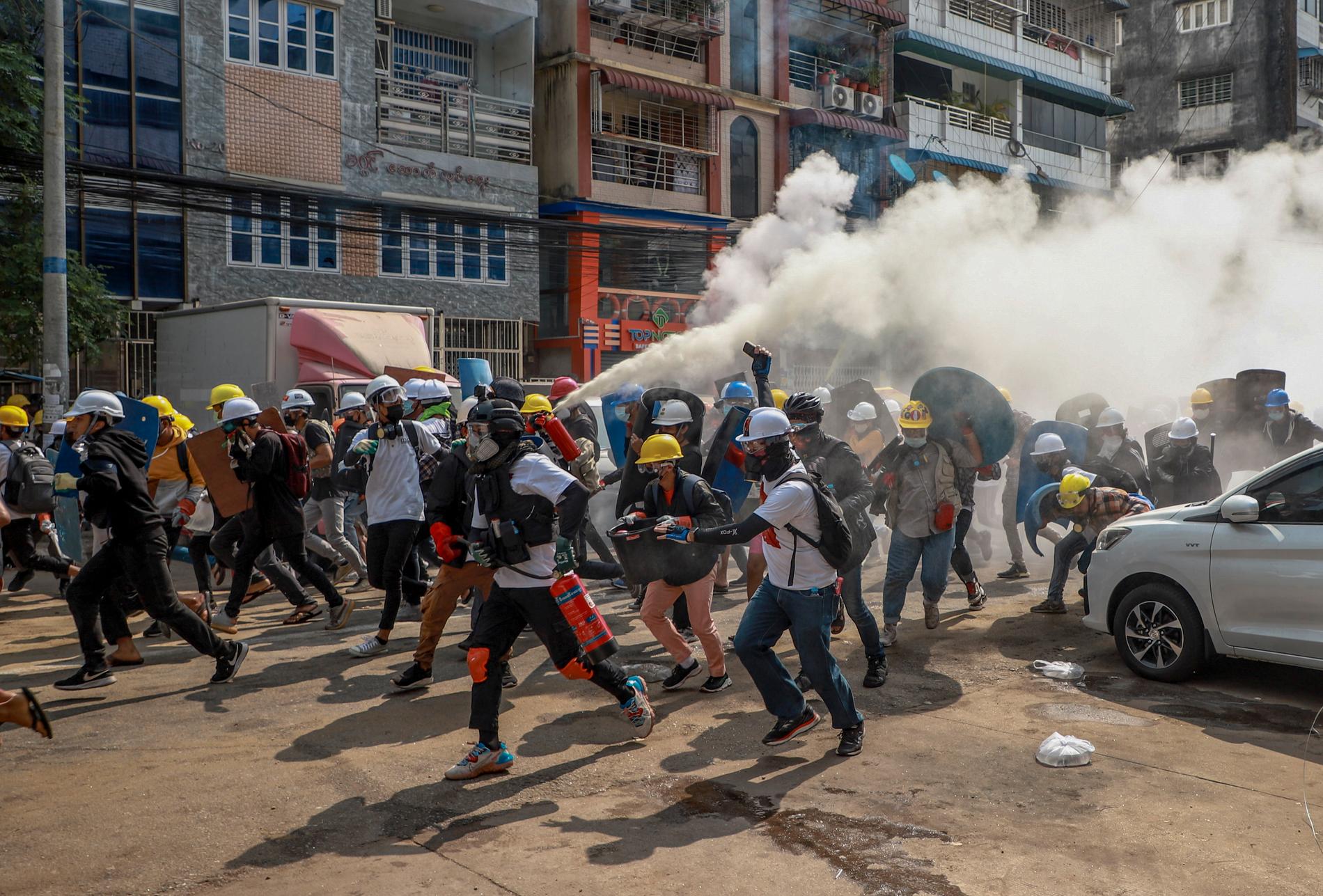 Onsdag 3 mars. Demonstranter använder brandsläckare för att motverka polisens tårgas i Rangoon. Man protesterar mot att militären tagit makten i landet.