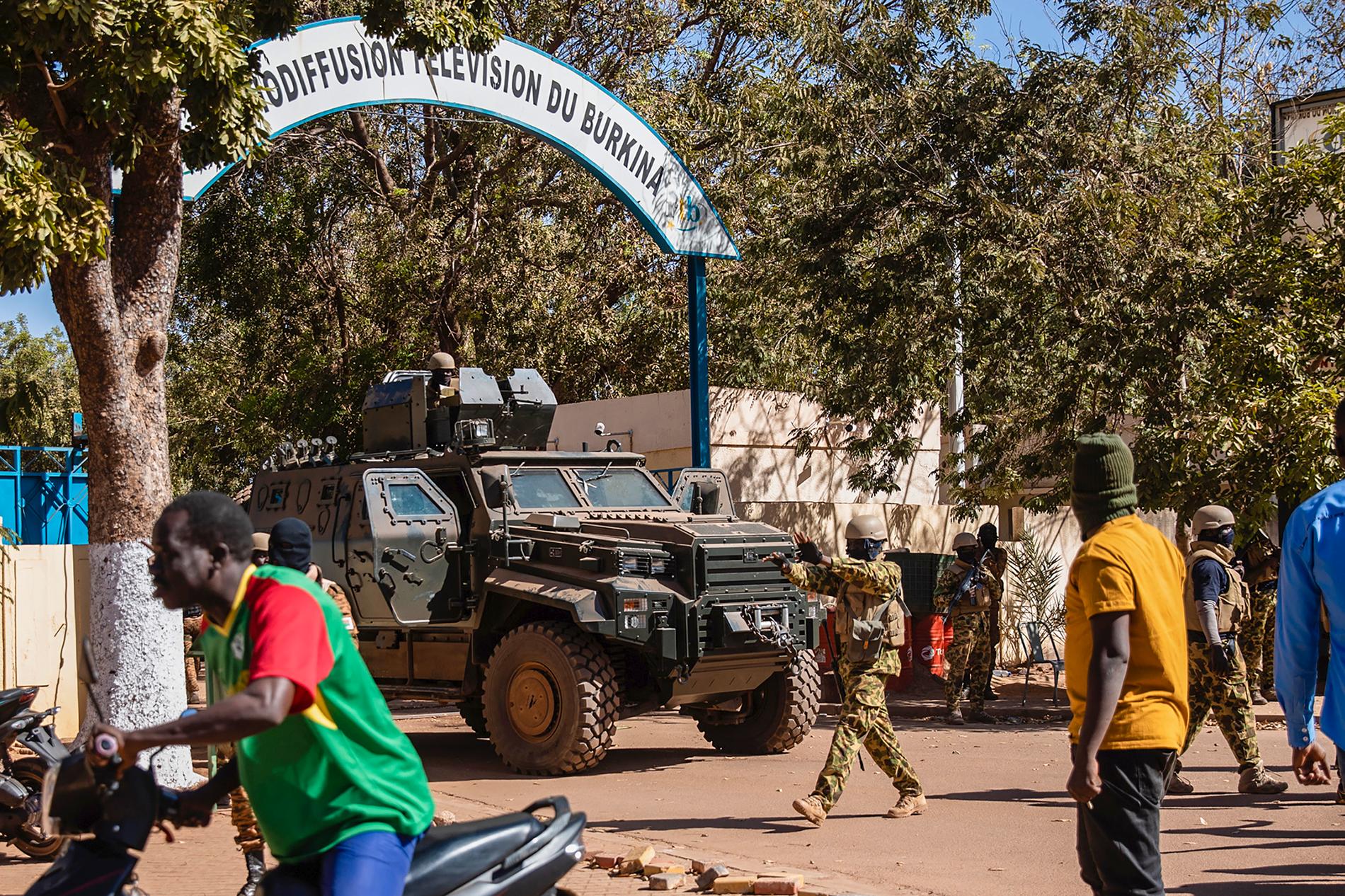 Upproriska soldater står vakt utanför det statliga tv-bolagets högkvarter i Ouagadougou under måndagen.