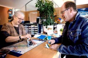 Aftonbladets reporter Sture Olsson passar på att få en stämpel i passet för 15 kronor av Marlise Huber-Schmitz på turistkontoret i Liechtenstein.