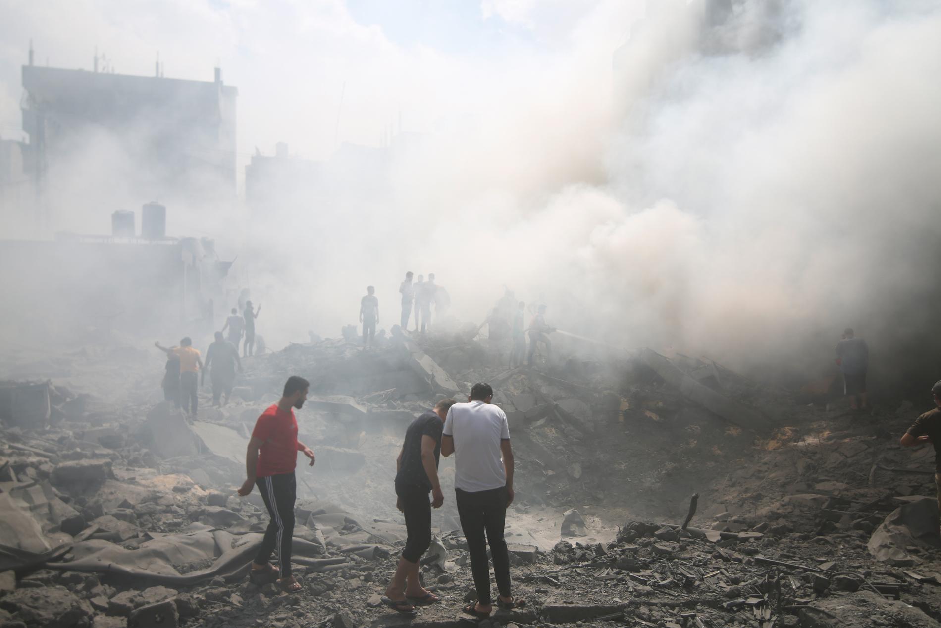 Palestinier letar efter överlevande efter en israelisk attack i Gaza på torsdagen. 