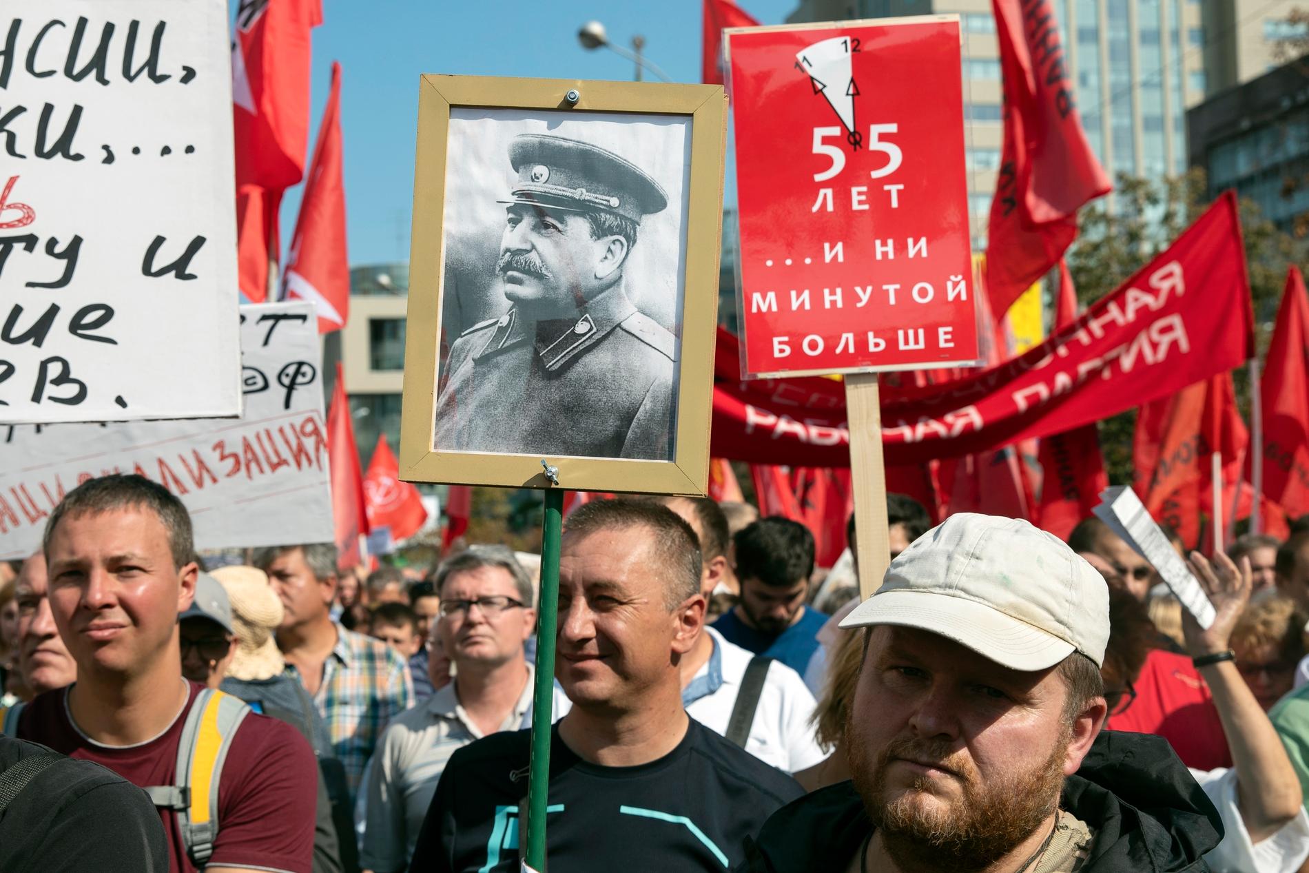 En man håller upp en bild på Sovjetunionens diktator Josef Stalin under söndagens protester i Moskva mot den ryska regeringens planerade pensionsreform.