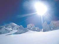Glaciärens isformationer gnistrar i det starka solljuset.