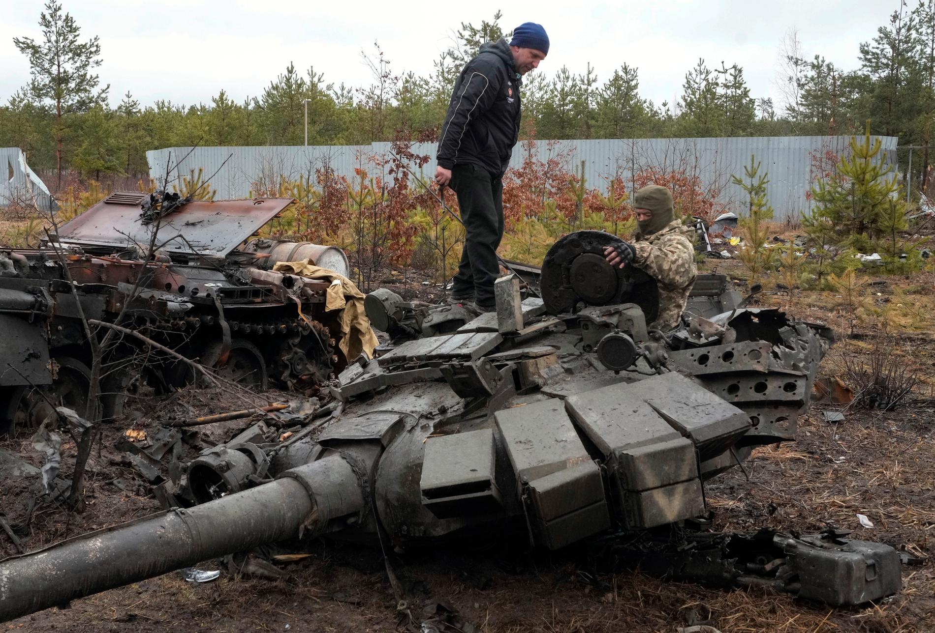 Ukrainska soldater undersöker en rysk stridsvagn. 