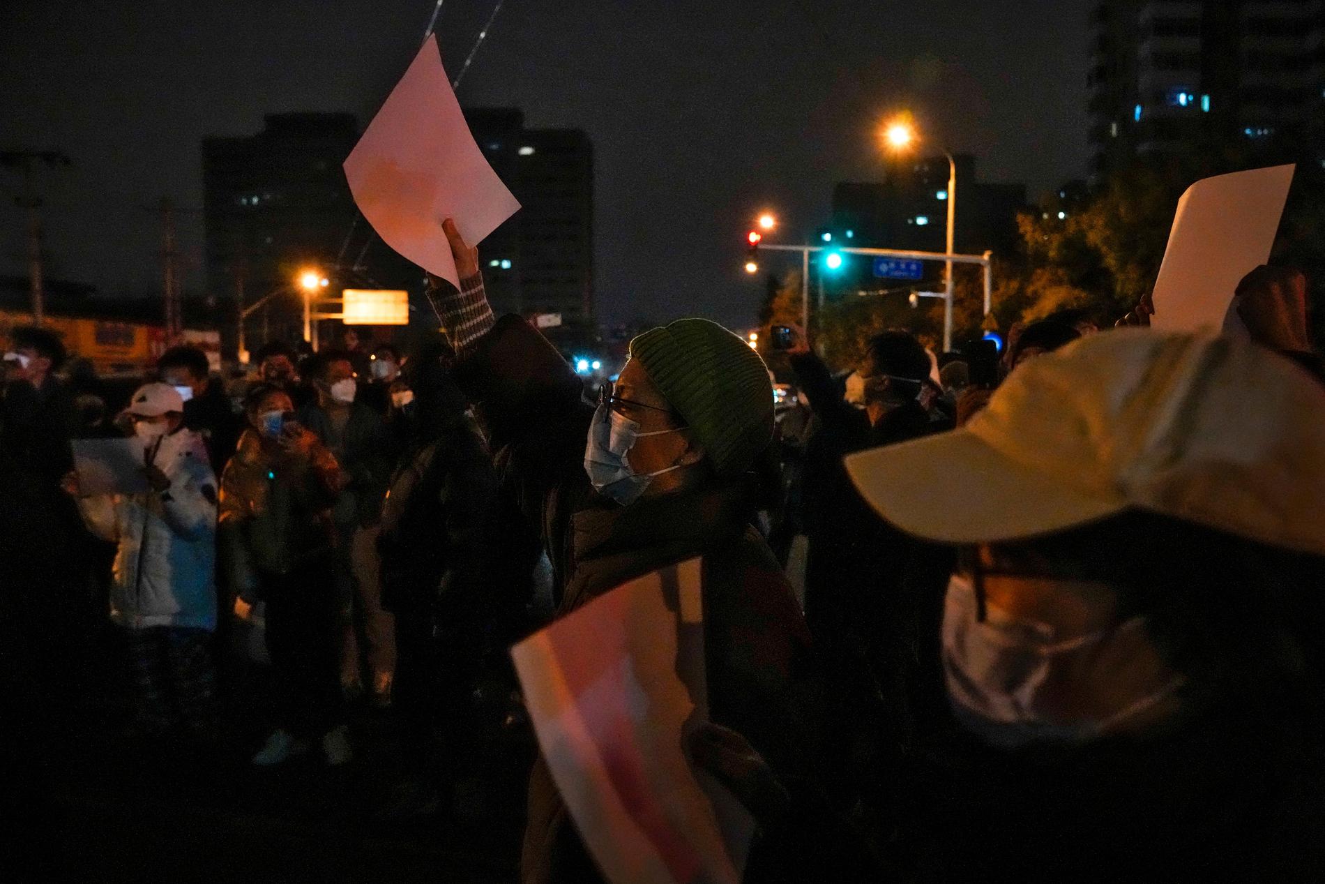 Tomma vita pappersark har under protesterna blivit en symbol för censur. Bilden är från en protest i Peking på söndagskvällen.