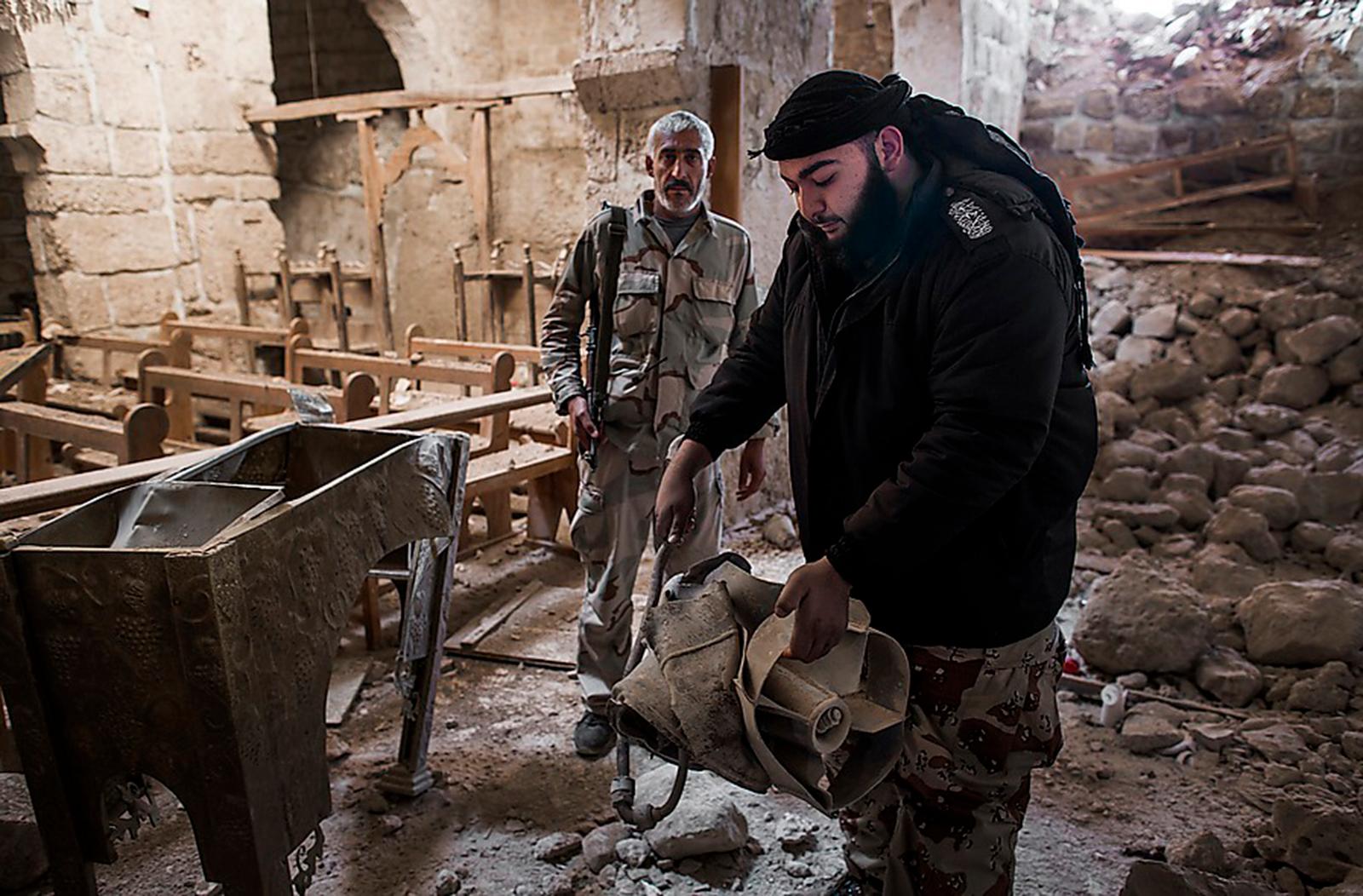 En gång hade Maaloula en vacker kyrka. FSA-krigaren Yessef visar upp en av bomberna som förstörde den. Al Aumda, 45, är stadens borgmästare och ledare för FSA-gruppen: ”Jag är så less på det här kriget”, säger han.