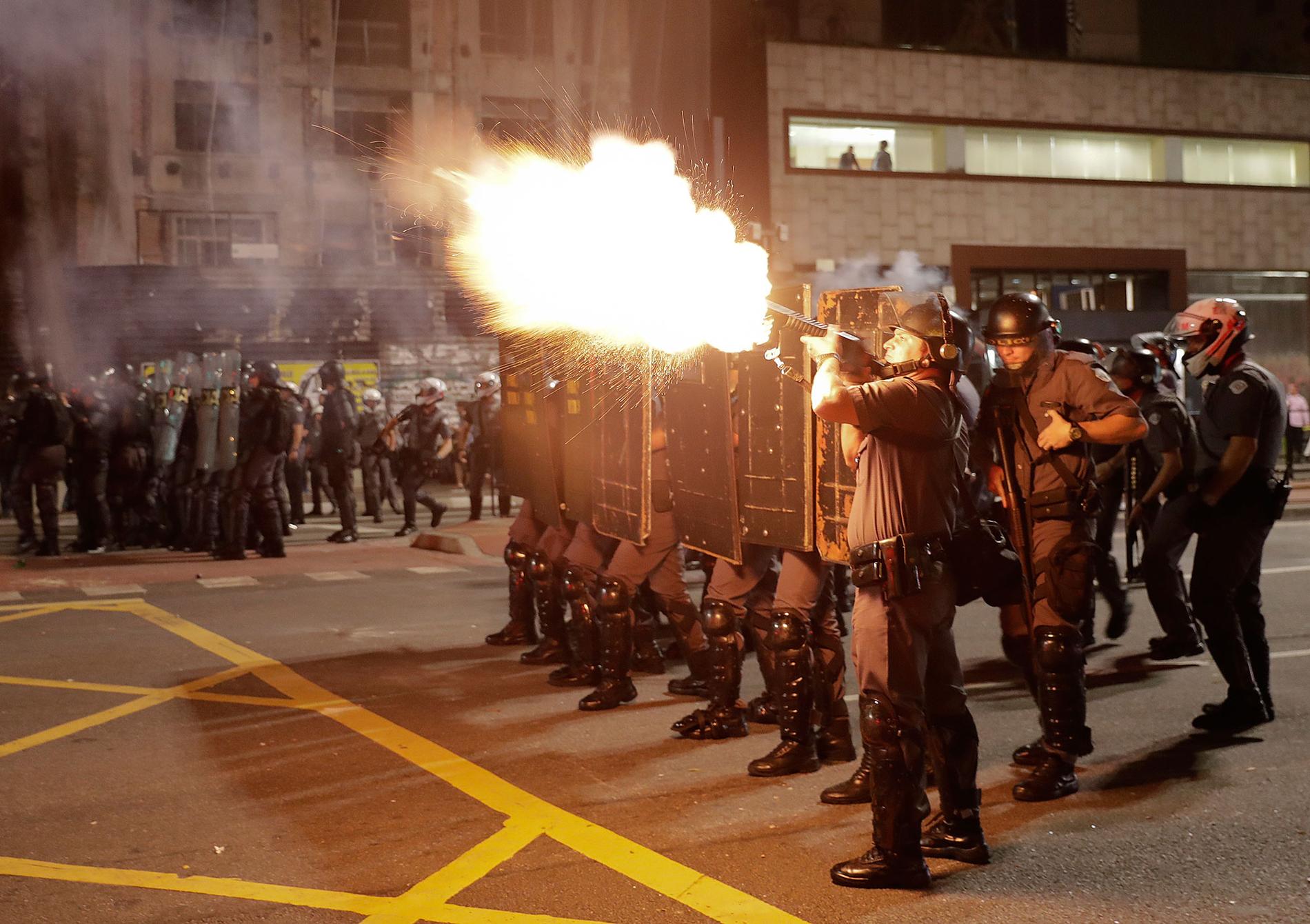 Polis avfyrar tårgas mot anhängare till Dilma Rousseff under en demonstration i Sao Paulo på måndagen.