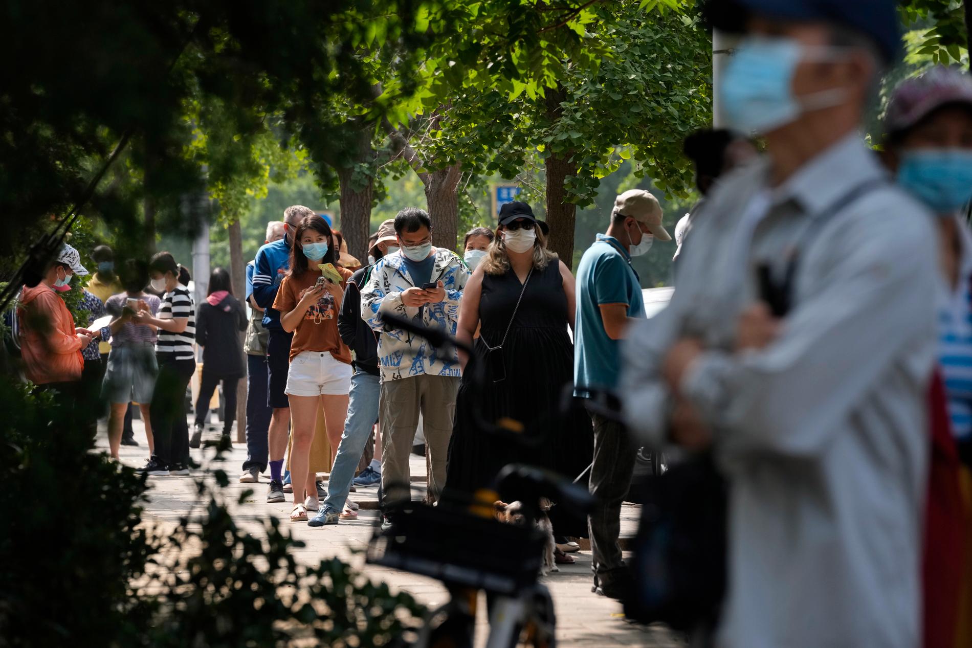 Invånare i Peking köar för att genomföra covid-19-test tisdagen den 14 juni.