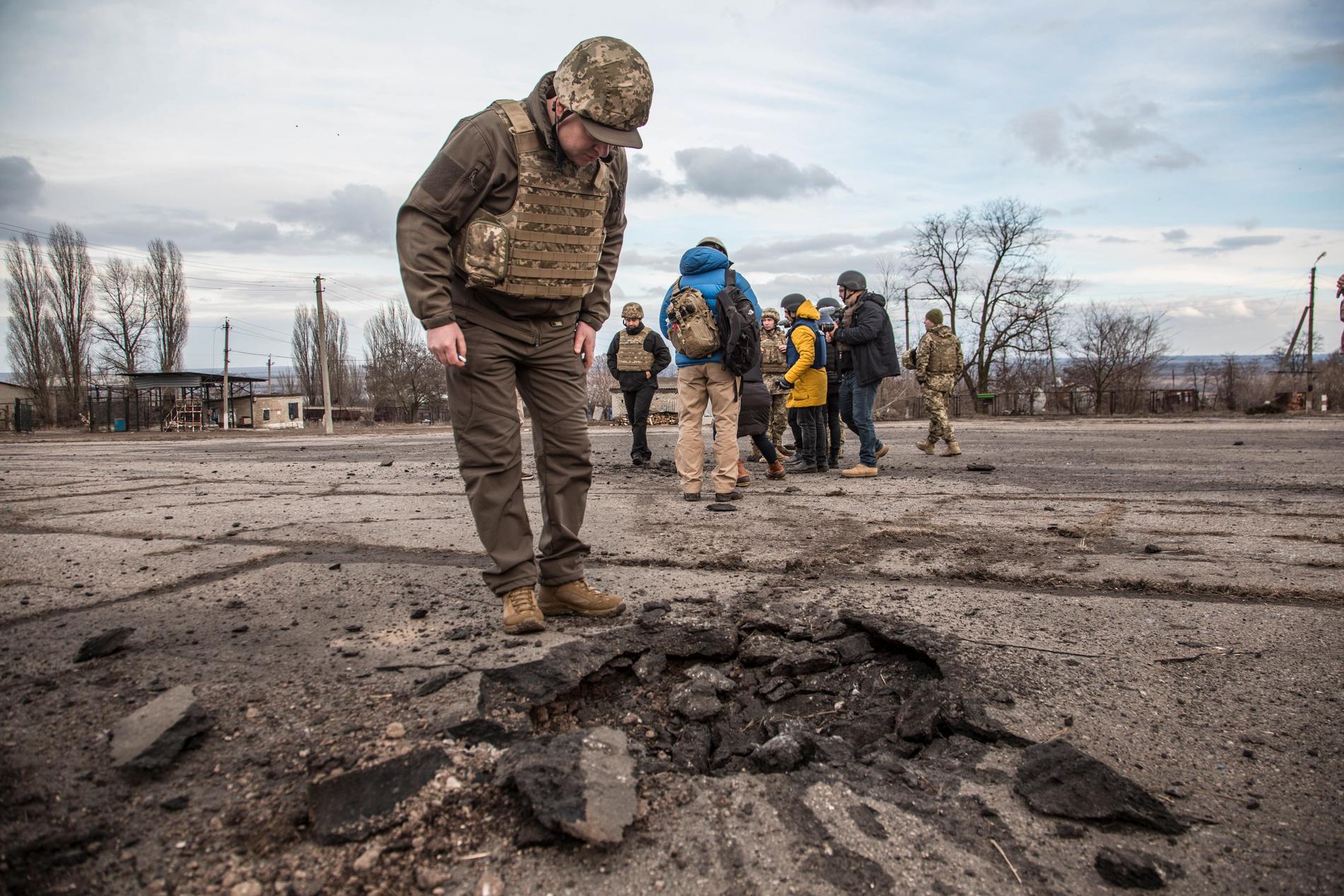 En ukrainsk soldat vid ett hål efter en attack av proryska separatister i Novoluhanske i Luhansk-regionen.