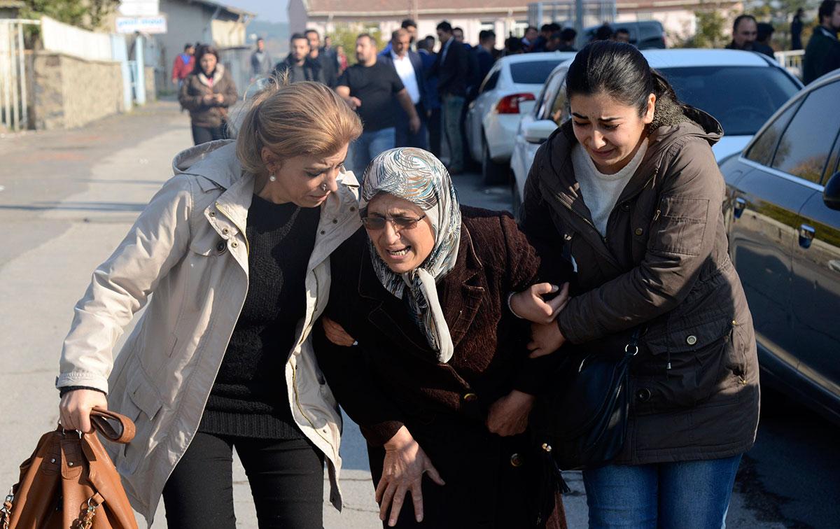 Tahir Elcis mamma, i mitten, kort efter att hennes son skjutits till döds.