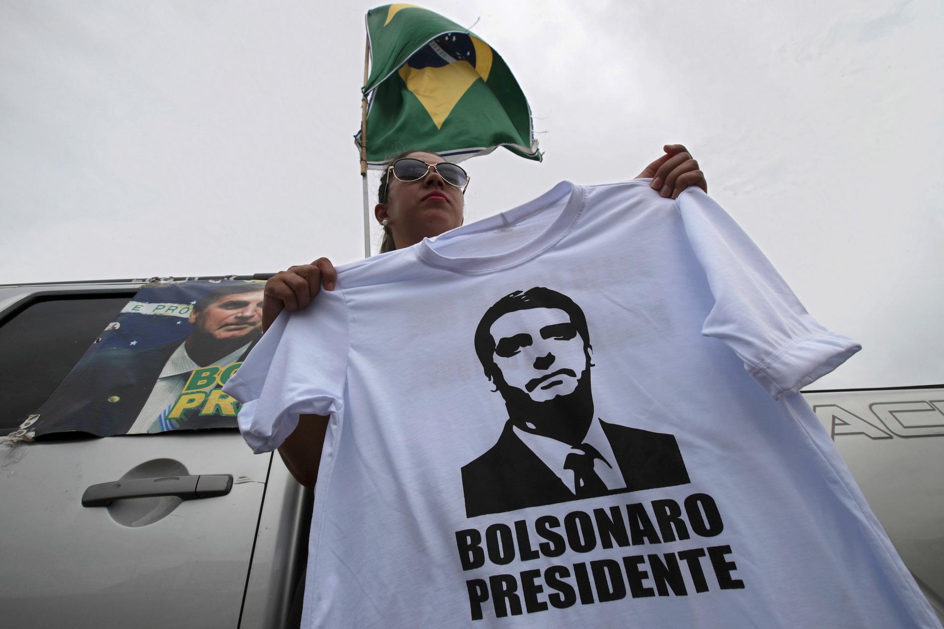En Bolsonarosupporter säljer tröjor med tryck föreställande sin kandidat vid en busstation i Brasilia, 17 oktober 2018.