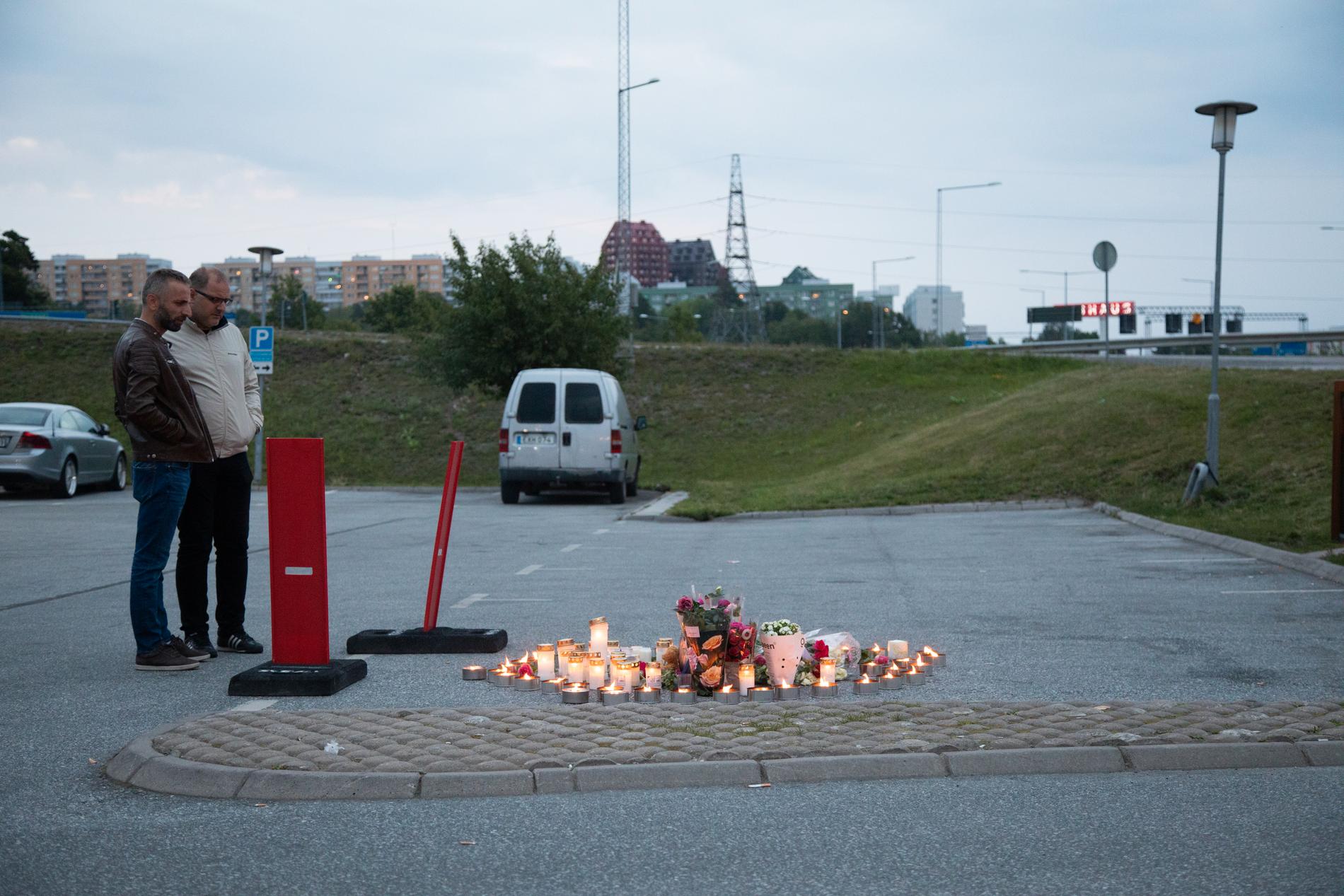 Blommor och ljus på platsen där en tolvårig flicka sköts vid en bensinmack i Botkyrka söder om Stockholm.