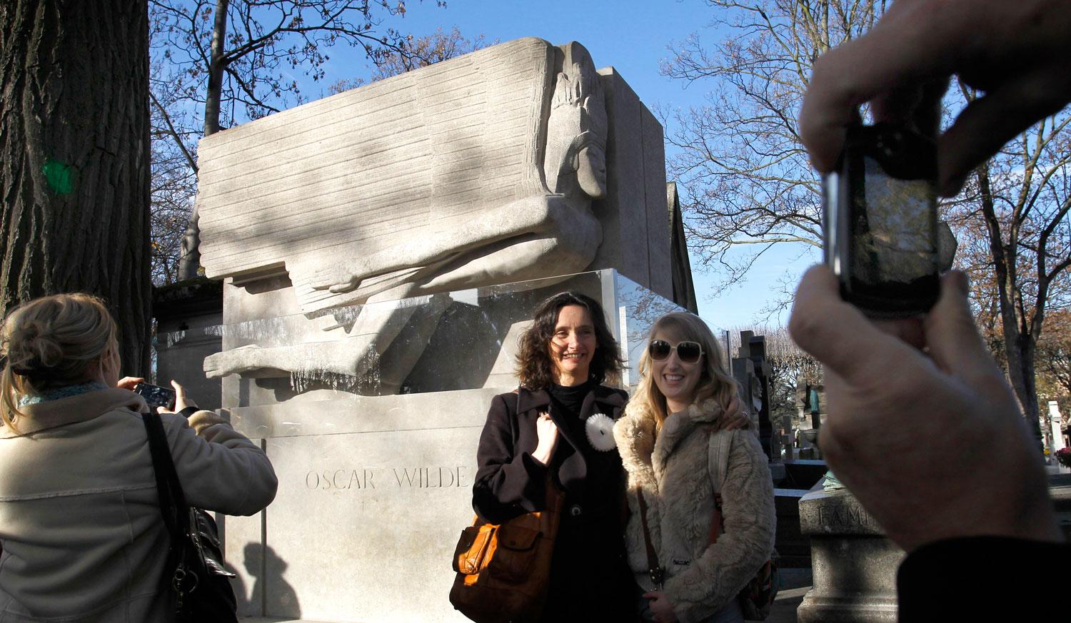 Turister samlas vid Oscar Wildes grav i Paris.