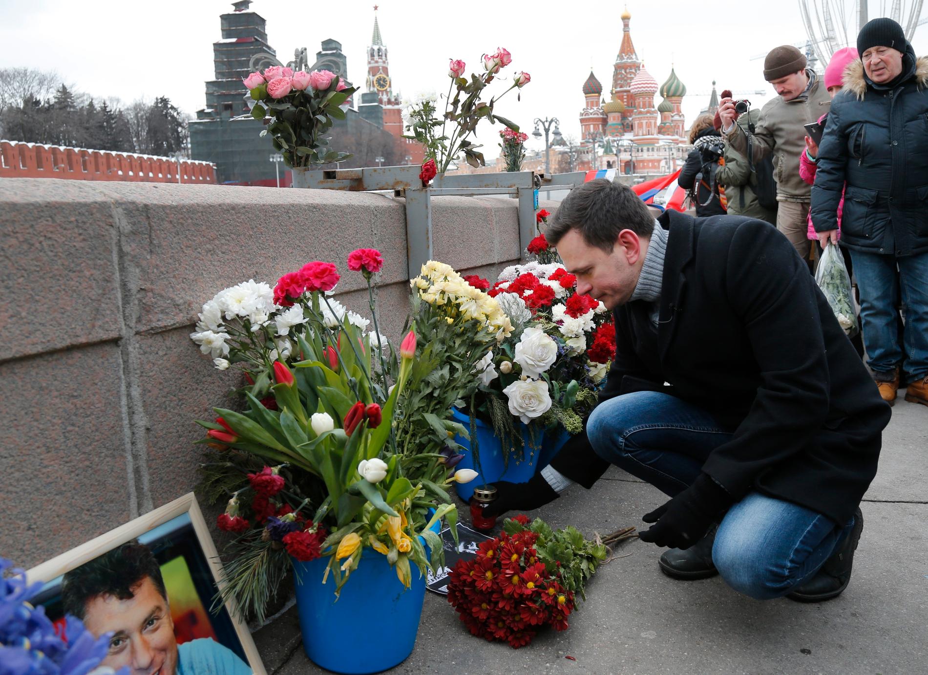 Den ryska oppositionsaktivisten Ilja Jasjin placerar blommor och ljus vid den plats där Boris Nemtsov sköts till döds för tre år sedan.