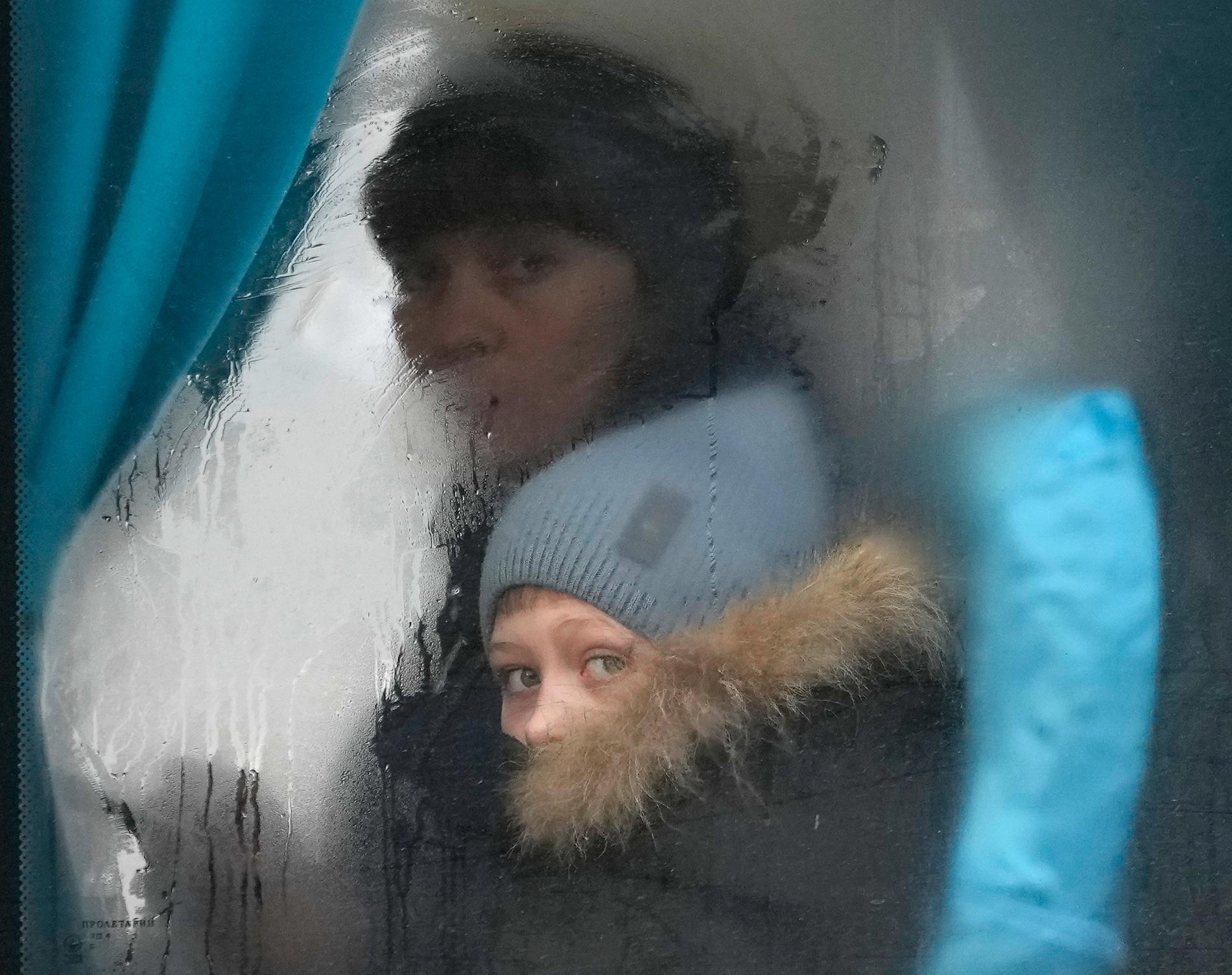 En kvinna och ett barn kikar ut genom fönstret från en evakueringsbuss i Sievierodonetsk i Luhansk i östra Ukraina.