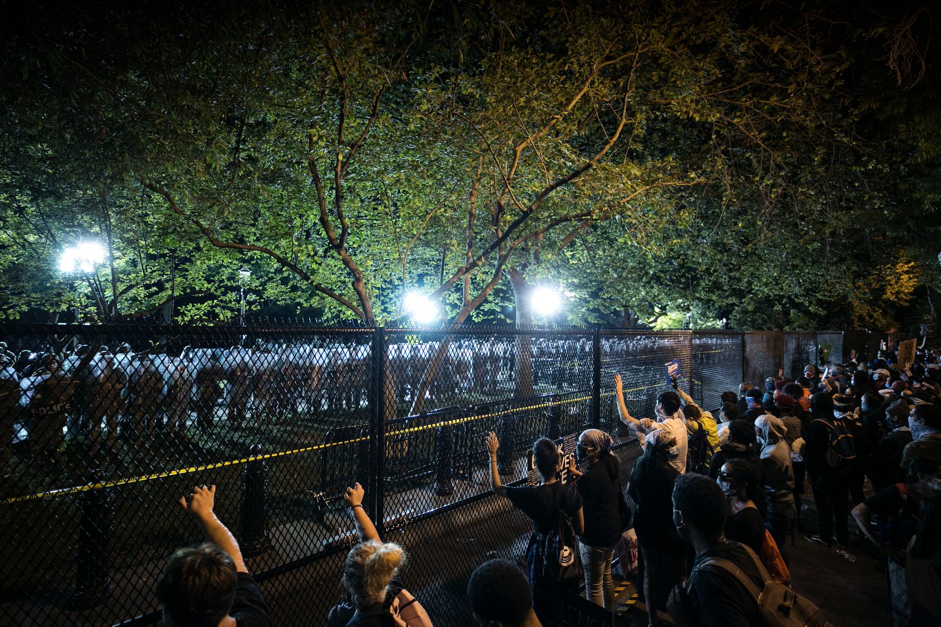Stora protester utanför Vita huset. Skrikande demonstranter skakar staketet.