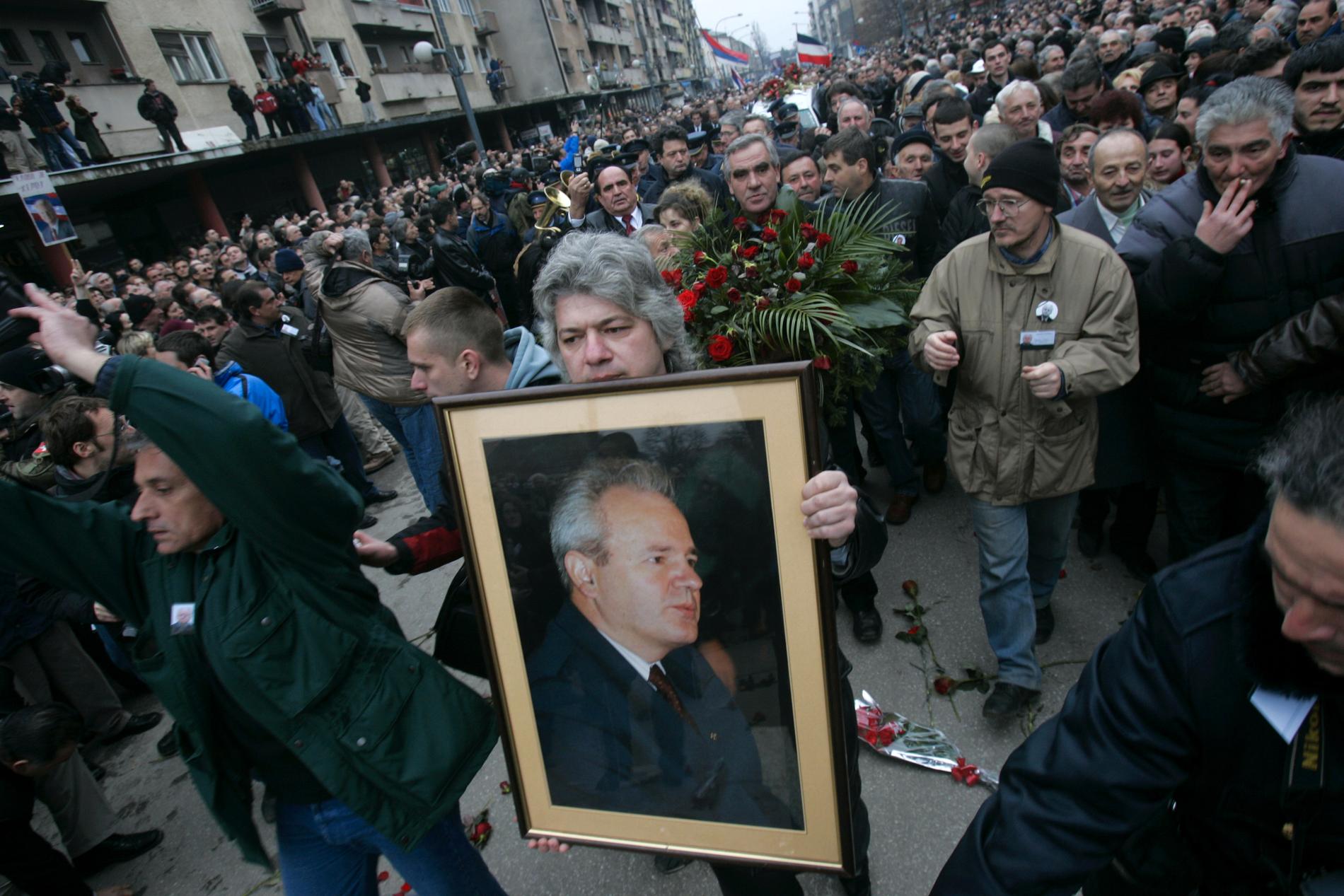 Anhängare till Slobodan Milosevic håller upp bilder föreställande den förre serbiske presidenten under hans begravning i Belgrad, 18 mars 2006.