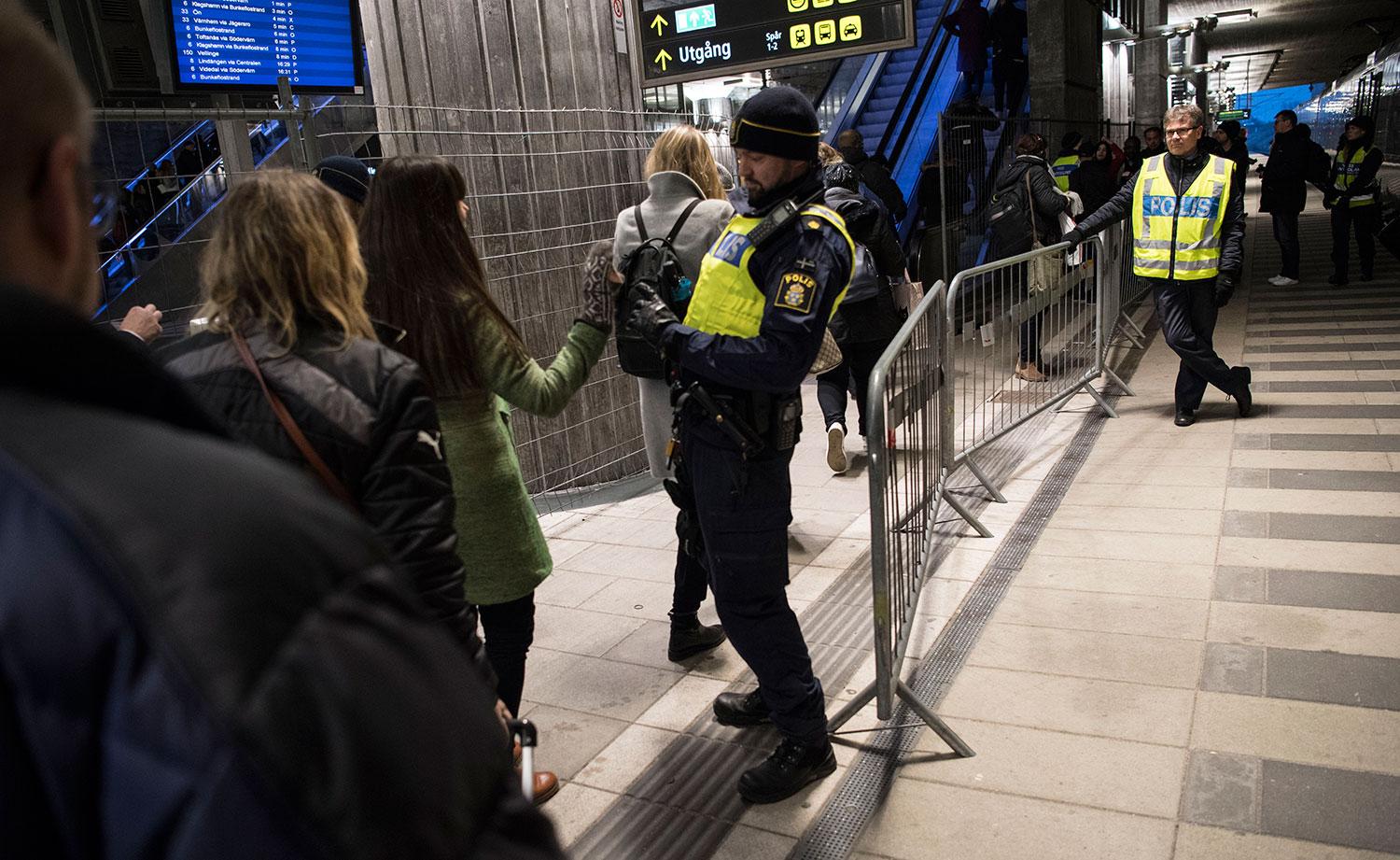 Passagerare visar id-handlingar i kontrollen på station Hyllie utanför Malmö.
