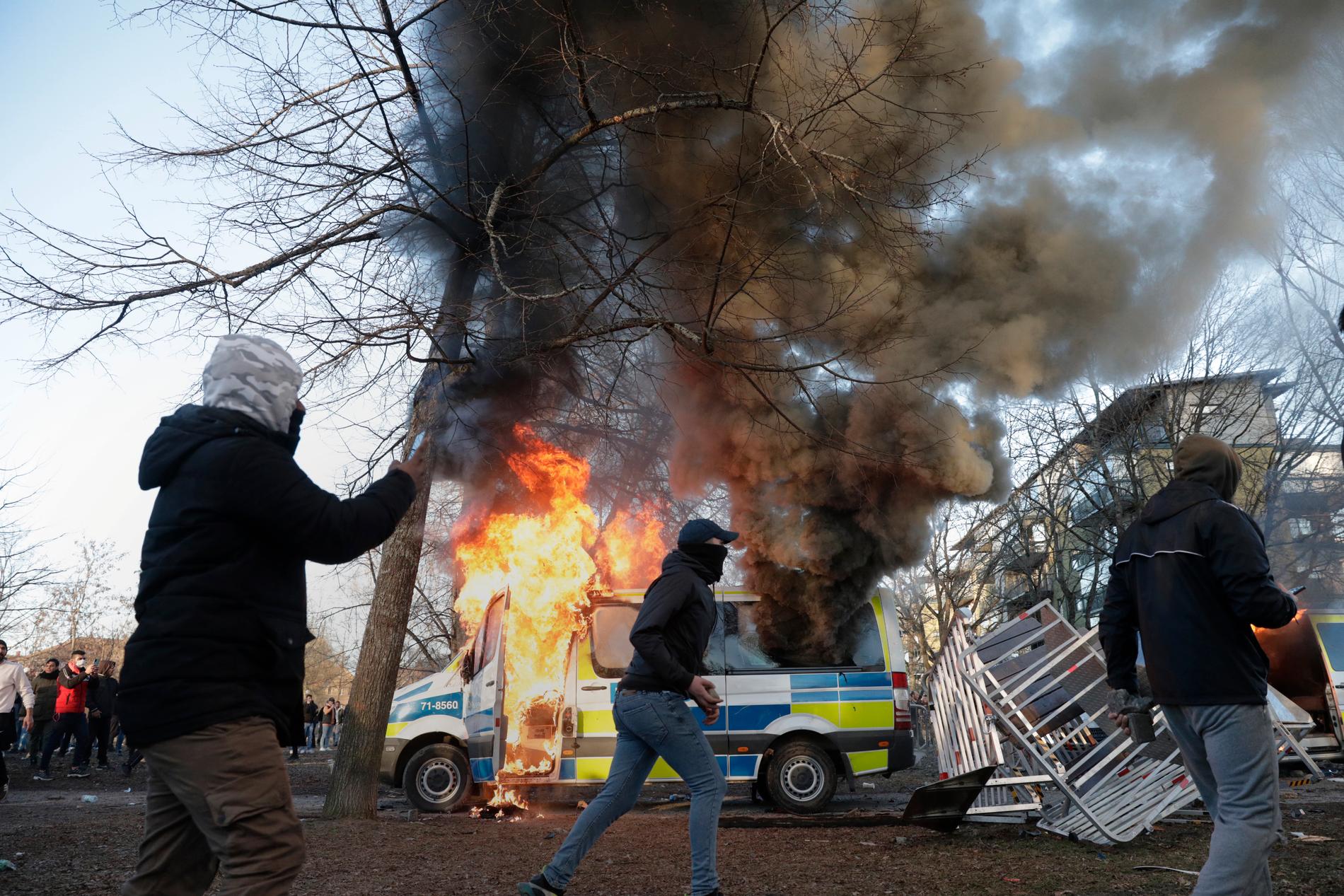 En polisbil brinner under långfredagens upplopp i Örebro. 