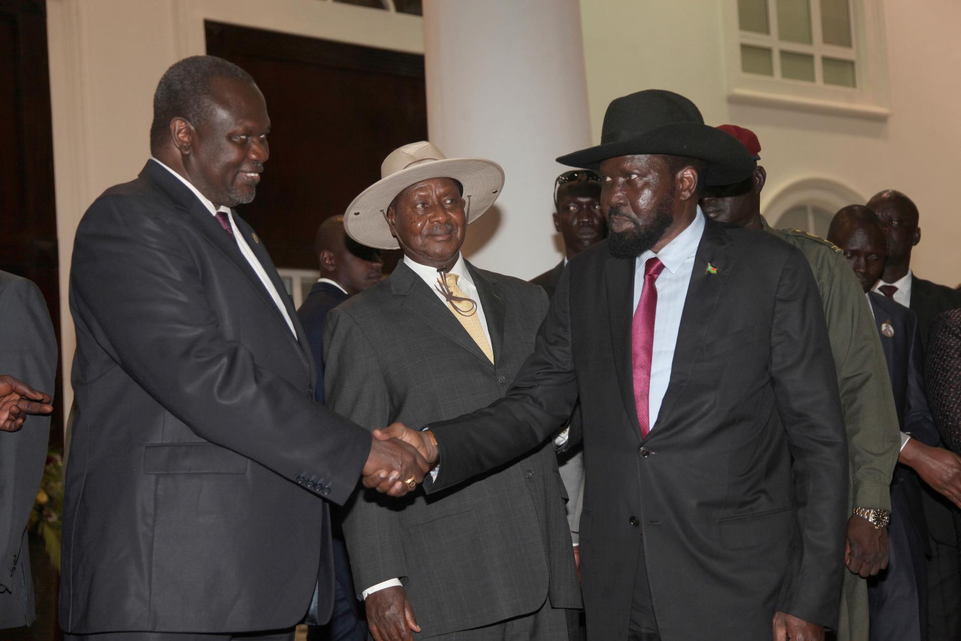 Sydsudans rebelledare Riek Machar (till vänster) skakar hand med presidenten Salva Kiir under ett möte i somras. Arkivbild.