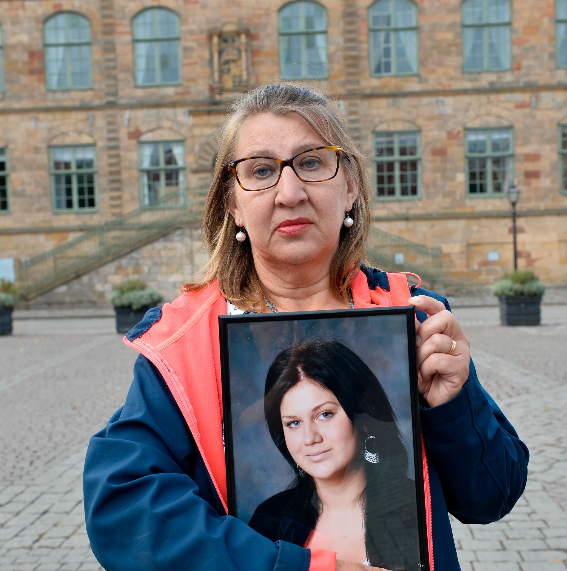 Gunilla Tholander med en bild på sin dotter Jennie Tholander utanför Göta hovrätt i Jönköping i augusti 2020. Jennie sköts i ansiktet två dagar efter att hon gjort slut med pojkvännen. 