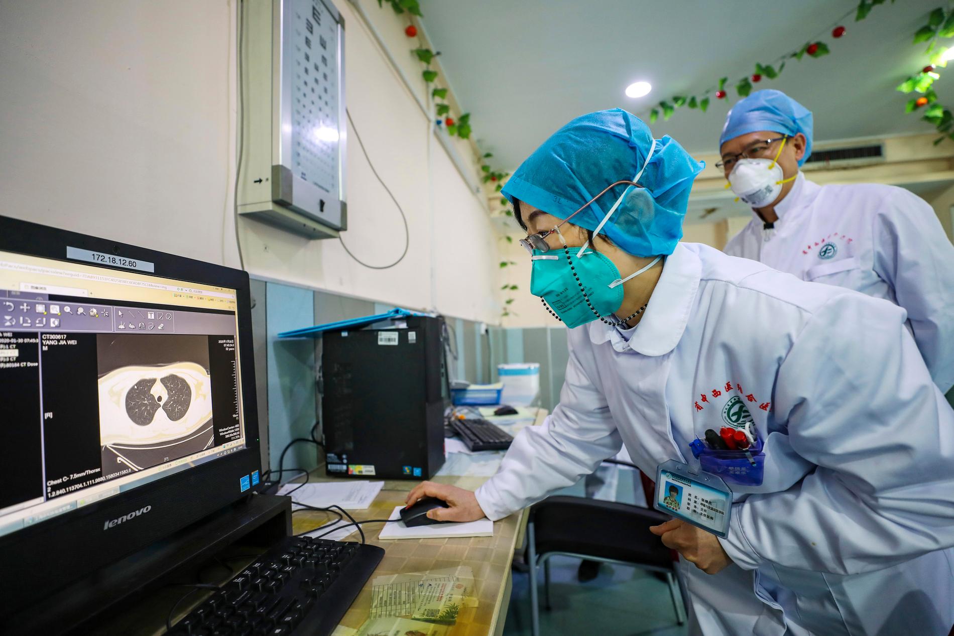 Läkare undersöker en patients lungor på ett sjukhus i Wuhan, Kina.