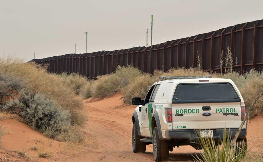 Amerikanska gränsvakter patruller vid befintligt stängsel vid gränsen mot Mexiko