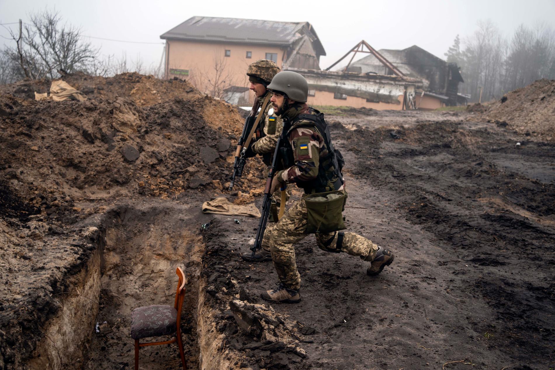 Ukrainska soldater inspekterar en tidigare rysk skyttegrav.