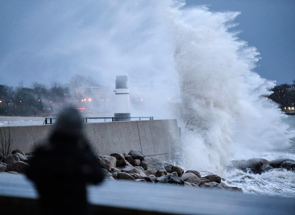 En våg slår över Västra Hamnens fyr i Malmö under stormen Egon på lördagen.