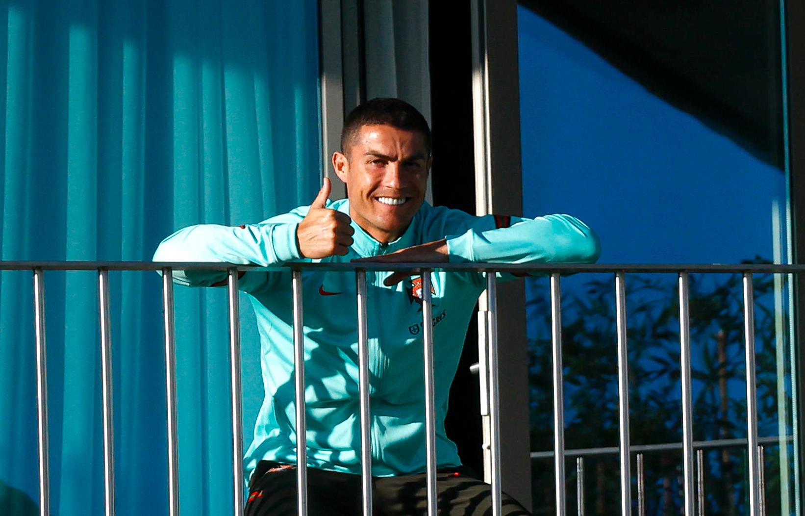Cristiano Ronaldo fick ta plats på en balkong vid Portugals träningsanläggning sedan det konstaterats att han testat positivt för covid-19.