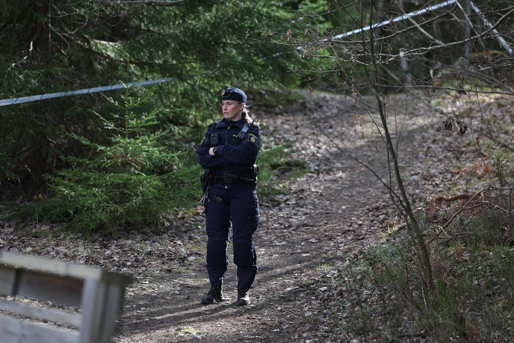En polis bevakar avspärrningen i området där kvinnan till slut hittades.