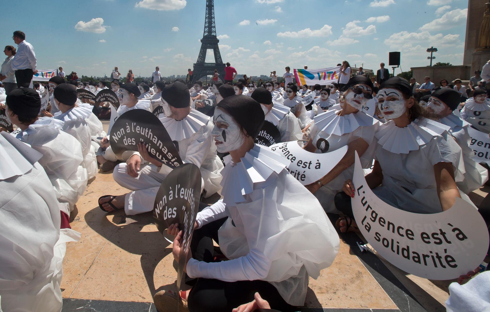 Demonstranter utklädda till mimare håller skyltar med texten "Nej till dödshjälp för 'gamla'" vid en manifestation i Paris. Arkivbild.