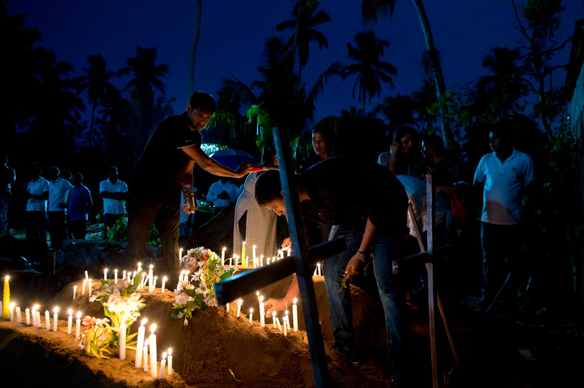 Släktingar tänder ljus för att hedra offren i Sri Lanka.