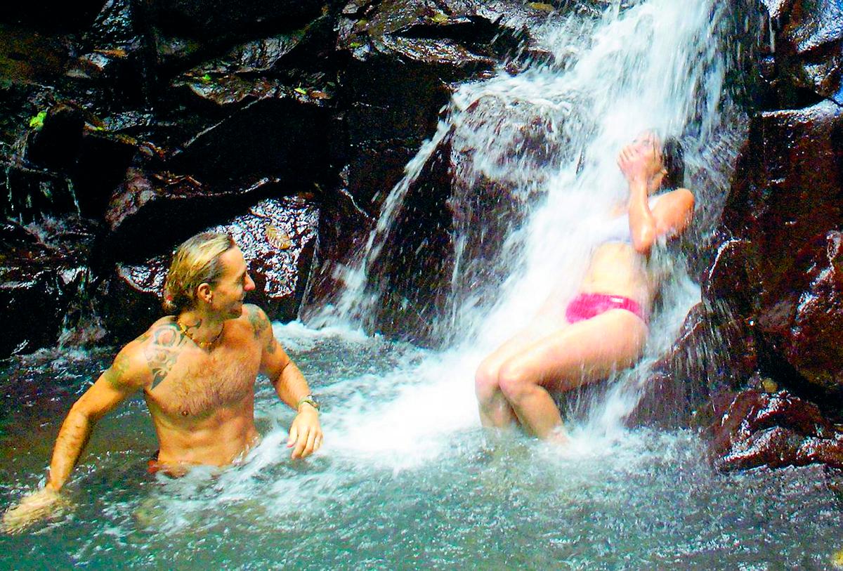 Djungelguiden Franck Dour svalkar sig i det 240 meter höga vattenfallet Les Chutes des Carbet i nationalparken på Basse Terre.