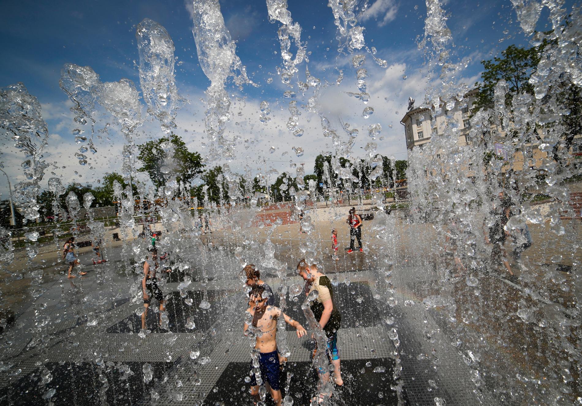 Barn leker i en fontän i Belarus huvudstad Minsk under sommarens värmevåg i landet.