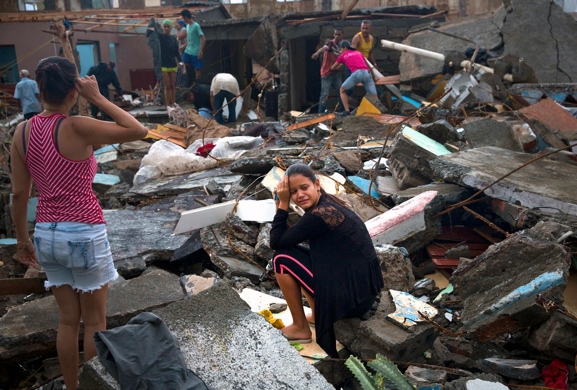 En kvinna på Kuba gråter i resterna efter hennes hem.