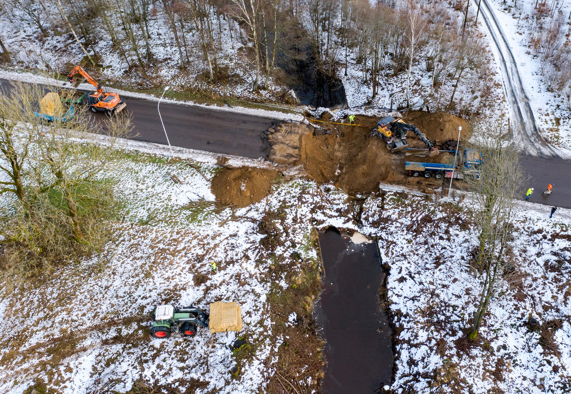 Grävskopor och manskap arbetar med att röja där en vägbro har rasat på Gustavsborgsvägen i Perstorp på torsdagen. Tunnlar under bron har gett vika.
