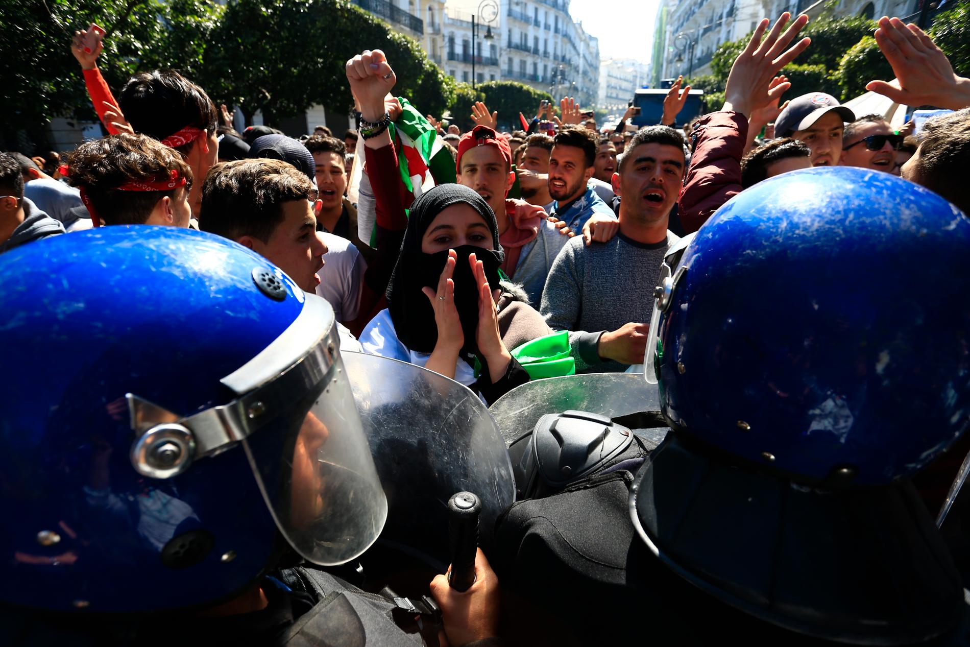 Protesterande gymnasielever och kravallpolis Algeriets huvudstad Alger på tisdagen.