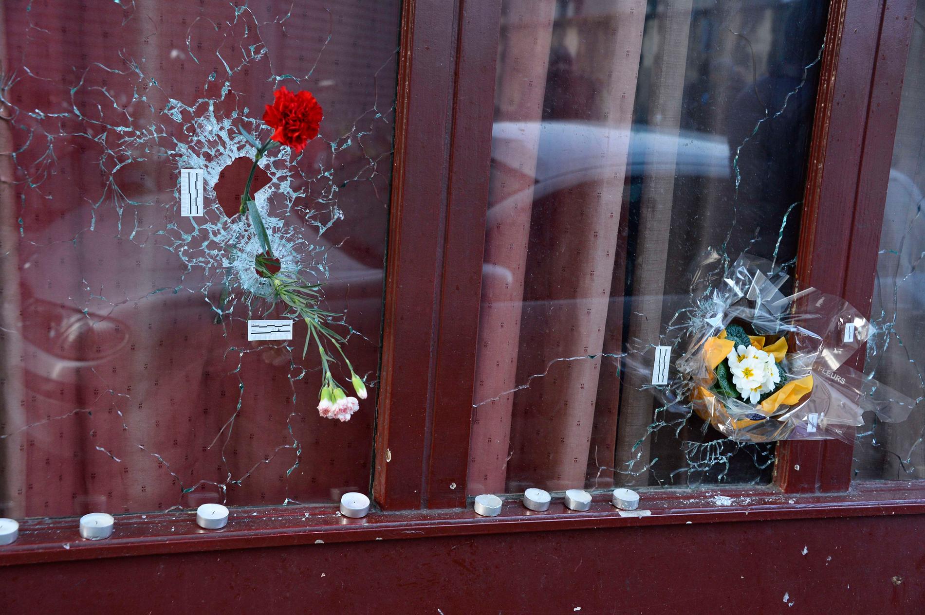 Blommor i fönstret på Carillon Café, som träffades av kulor under attackerna i Paris. Foto: AP