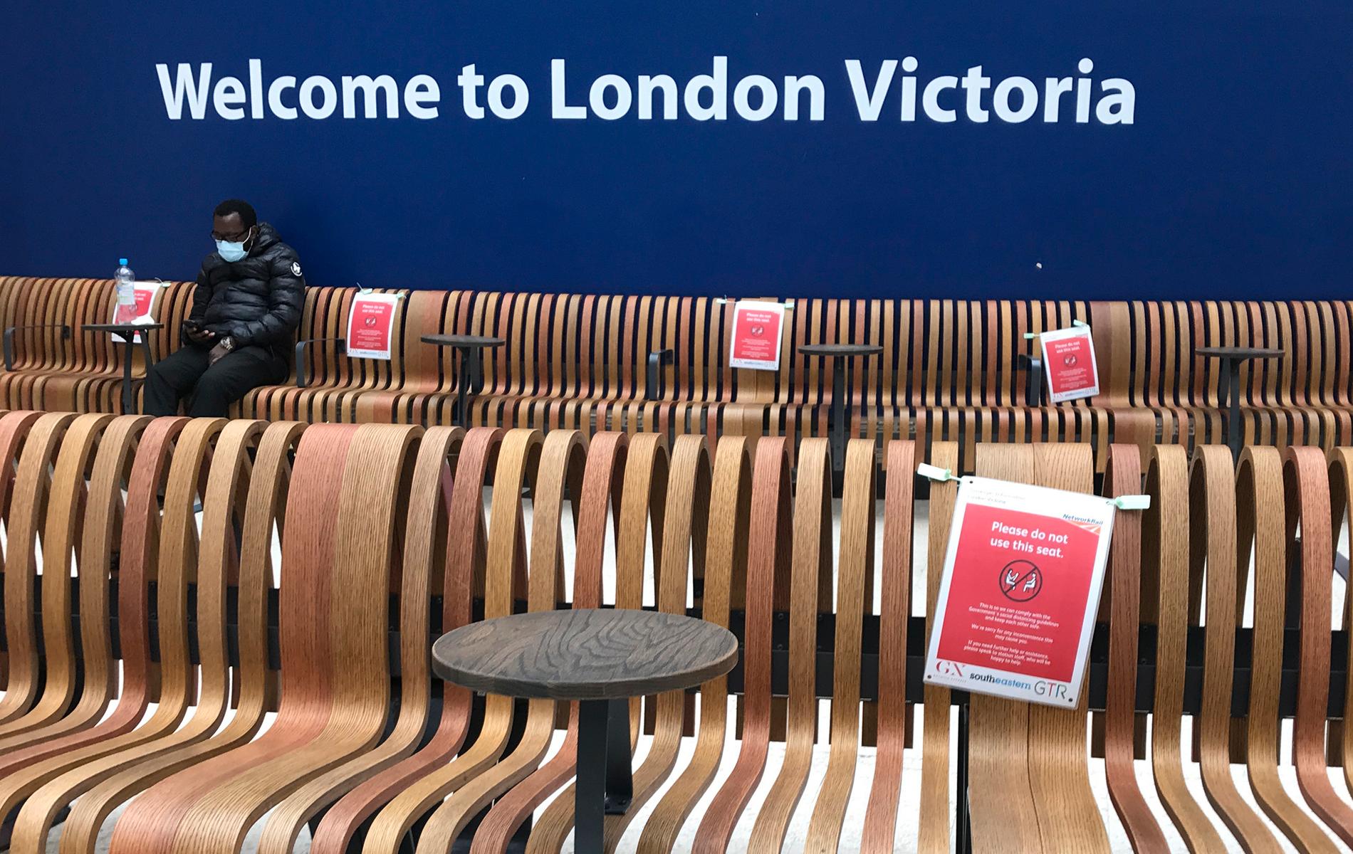 Skyltar i vänthallen på Victoria station i London manar besökare att hålla avstånd. En anställd på stationen dog sedan en man som sade sig vara coronasmittad hostade och spottade mot henne. Bild från tidigare i veckan.