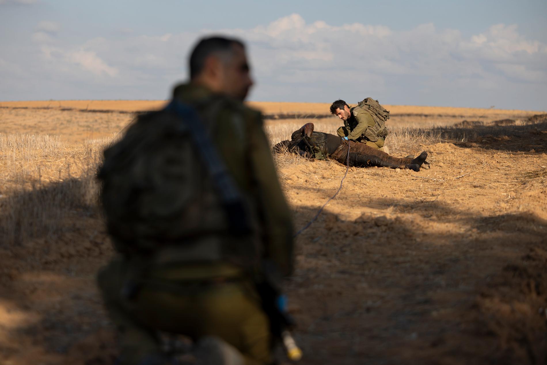 En israelisk minröjare plockar bort sprängmedel från en död Hamaskrigare.