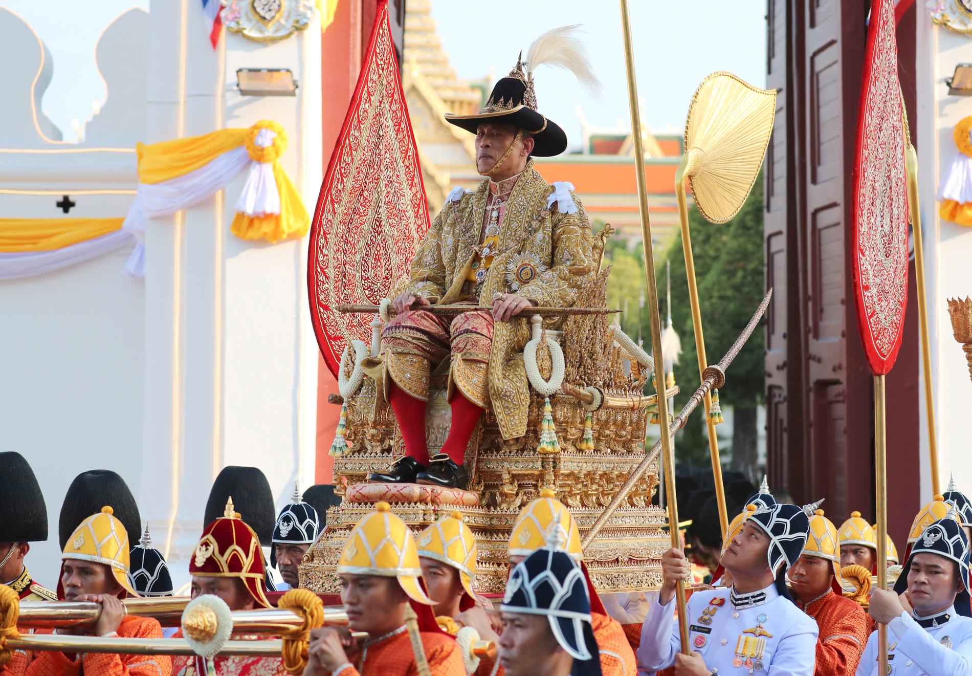 Thailands nykrönte kung Rama X bars genom Bangkok av soldater.