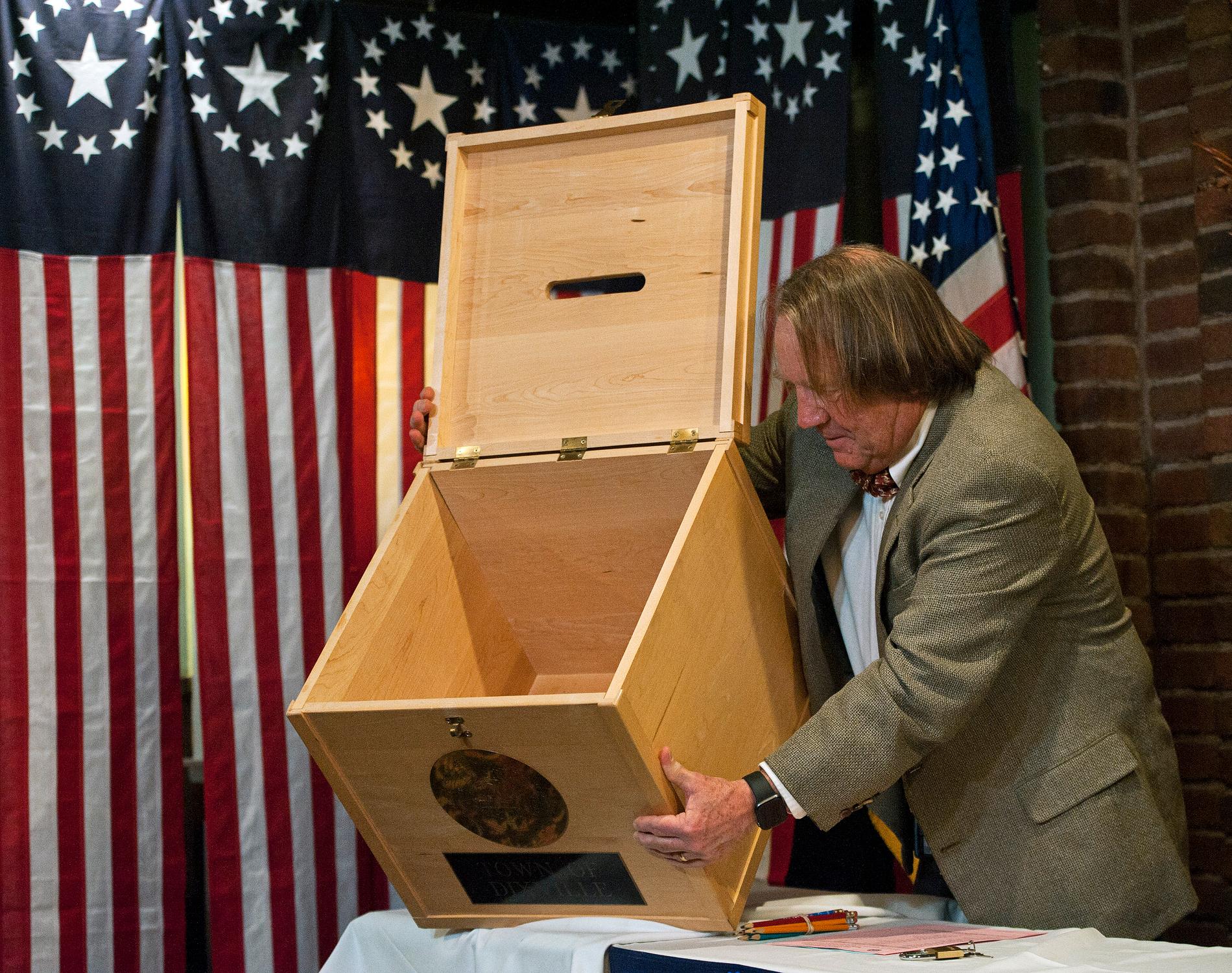 ValförrättarenTom Tillotson visar den tomma urnan strax innan midnattsvalet i Dixville Notch i New Hampshire i USA drar igång.