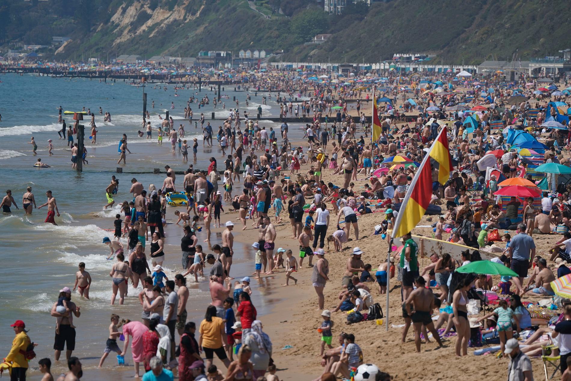 Britter på stranden i Bournemouth i södra England, måndagen den 31 maj 2021. Sommarvärmen lockar många att pusha den senaste tidens lättnader av coronarestriktionerna. 