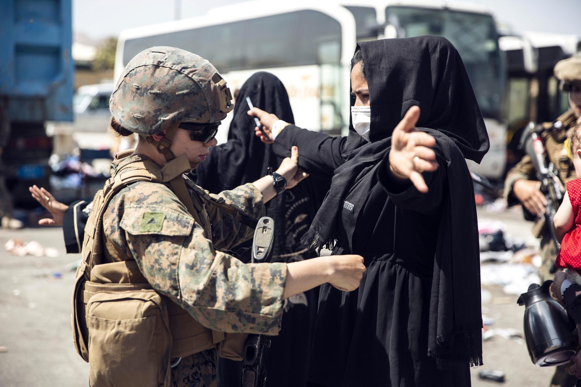 En amerikansk soldat kontrollerar en afghansk kvinna vid flygplatsen i Kabul. Nu har USA lämnat landet. 