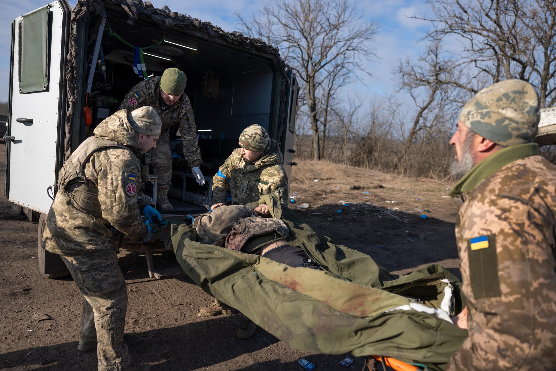Vladimir, 29, och hans kollegor bär in en soldat som blivit splitterskadad av en rysk kamikaze drönare. 