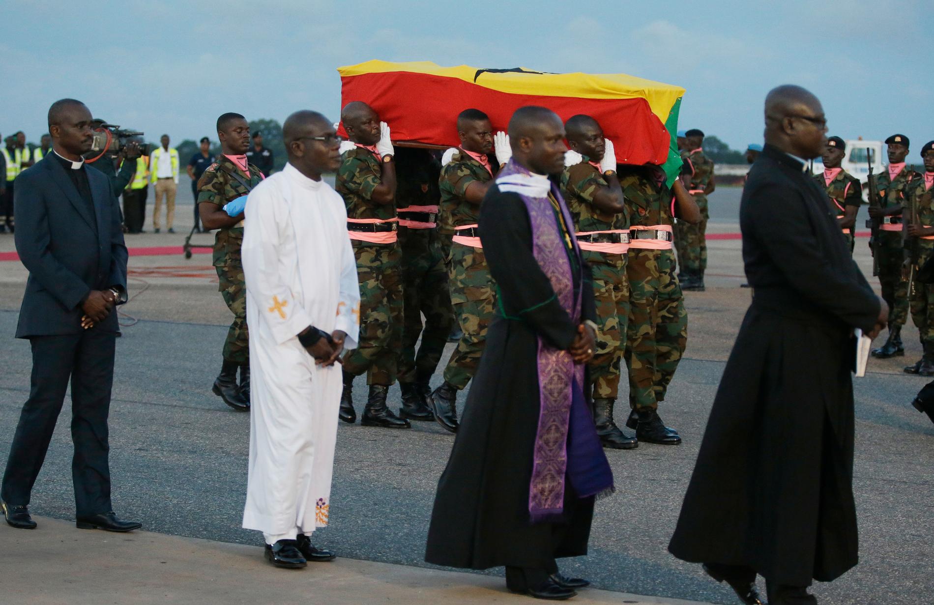 Kofi Annans kista, klädd i Ghanas flagga, bärs av soldater då den togs emot på flygplatsen Kotoka i Accra på måndagen.