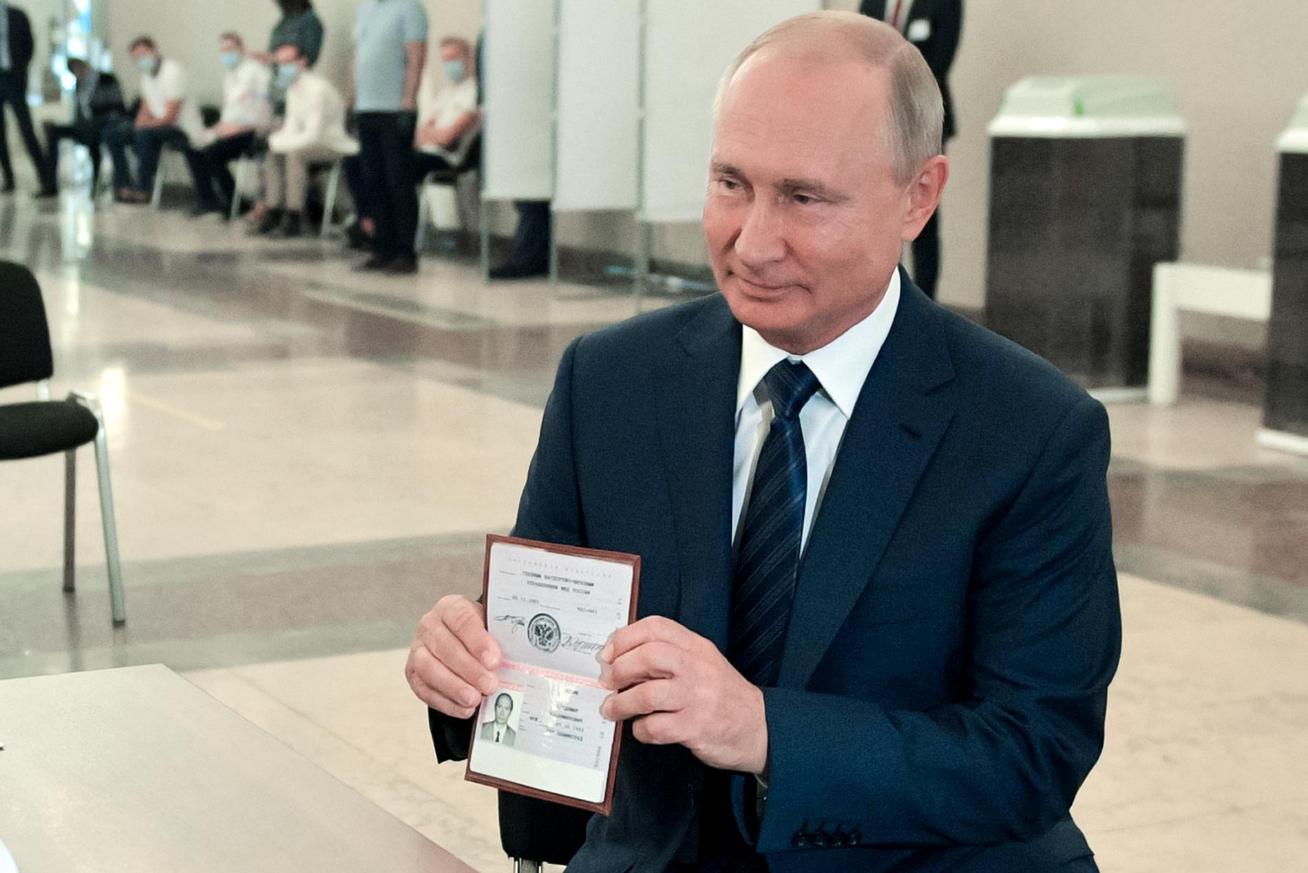 Putin håller upp sitt ryska pass i samband med att han röstar. Bilden är från juli 2020.
