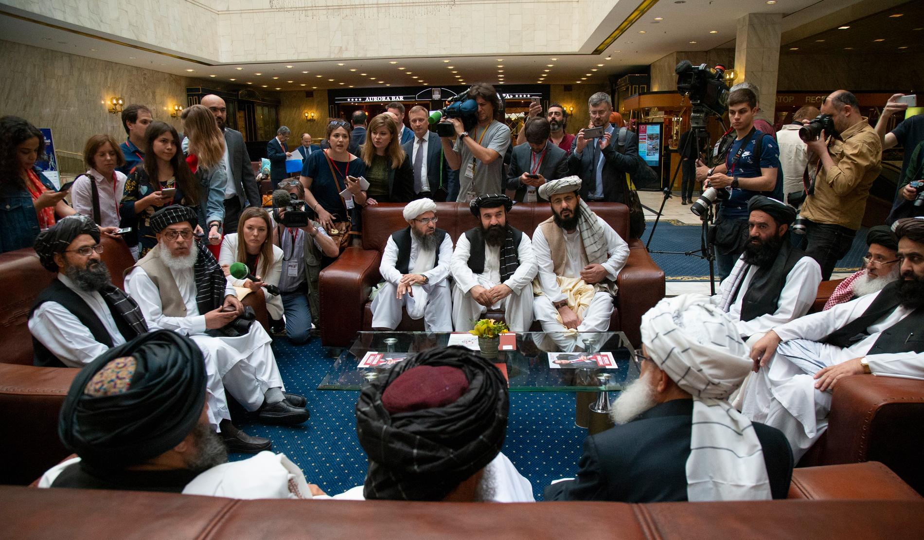 Representanter från talibanrörelsen talar med reportrar under fredssamtal i juni i år.